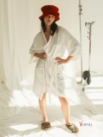 Weißer Satin-Brautkimono mit roten Paspel-Akzenten, vorne geschlossen, Modell zeigt Vorderansicht.